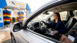 Busy driver entering drive-through car wash lane