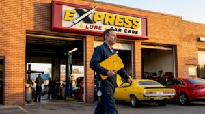 Mechanic walking outside auto repair shop entrance