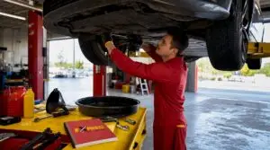Mechanic performing quick lube oil change in garage
