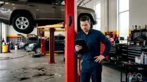 Technician reviewing service categories near vehicle