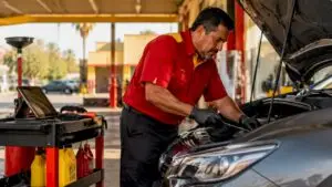 Mechanic performing vehicle oil change in service bay
