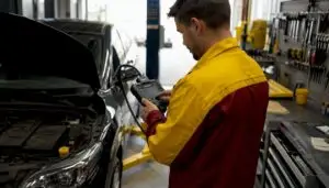 Mechanic using scan tool on car engine