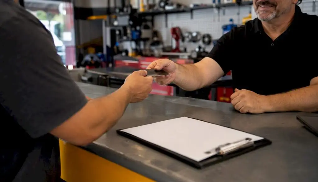 Hands exchanging credit card at auto repair counter