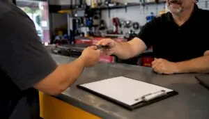 Hands exchanging credit card at auto repair counter