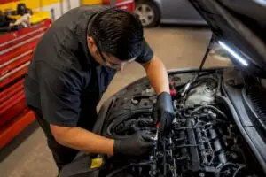 Technician replacing spark plugs during tune-up