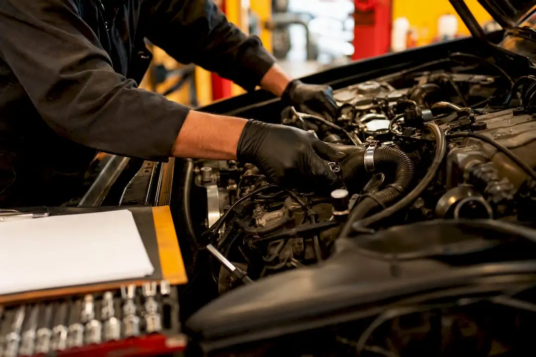 Technician removing fan shroud to access engine belt