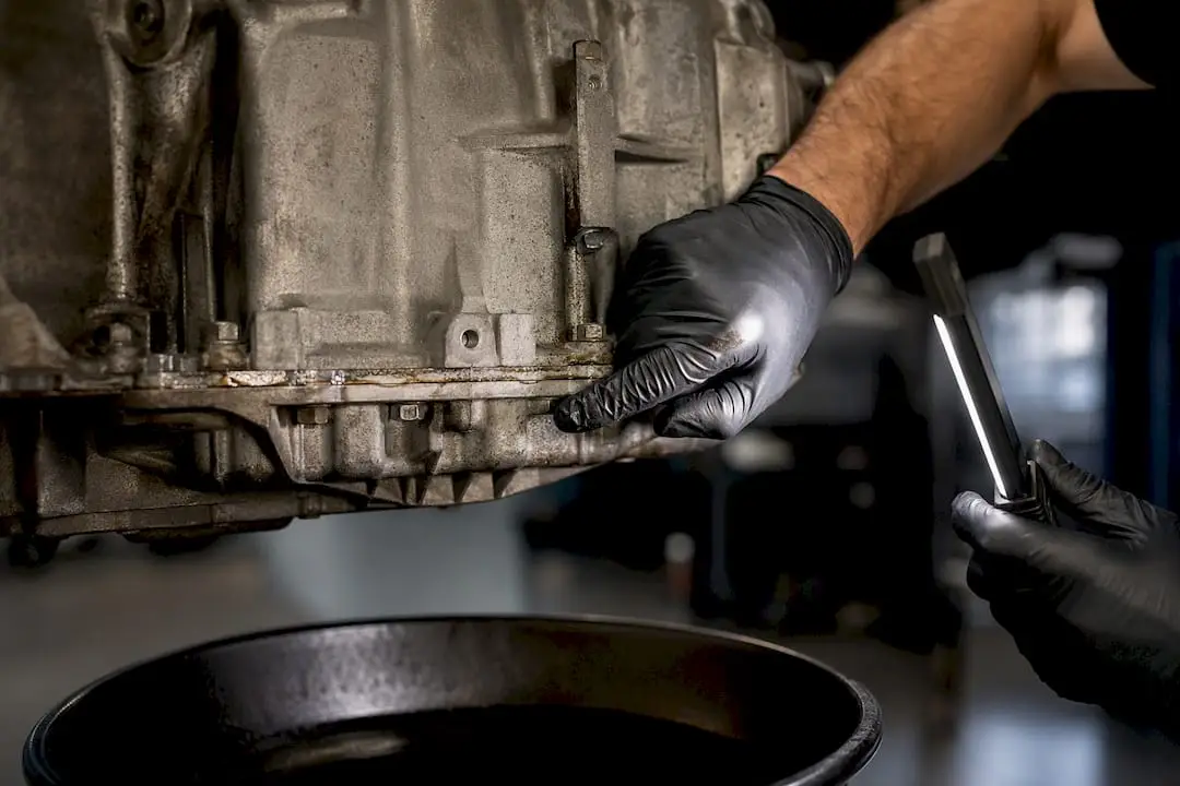 Technician inspecting transmission fluid leak